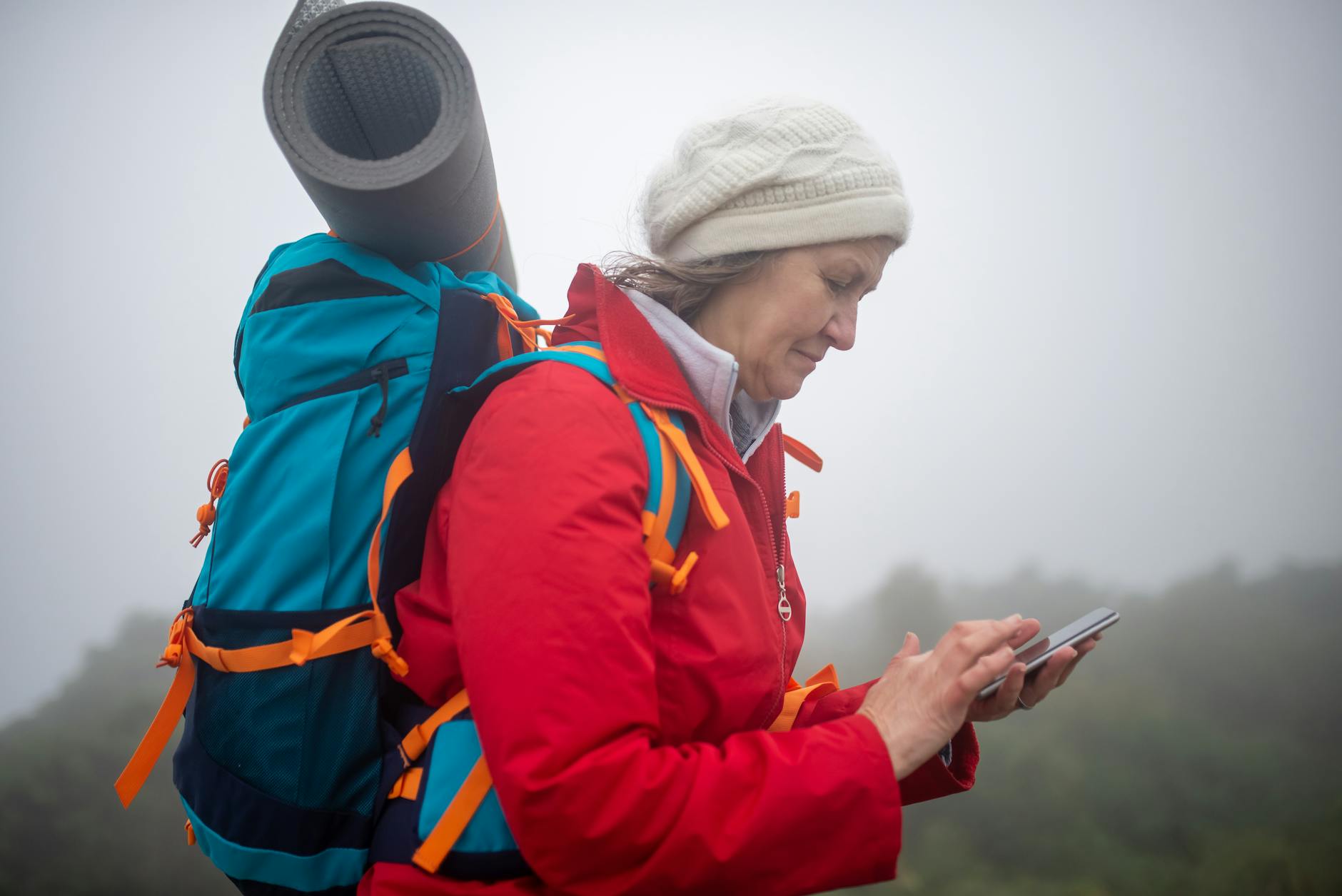 Randonneur utilisant une application GPS sur smartphone en forêt